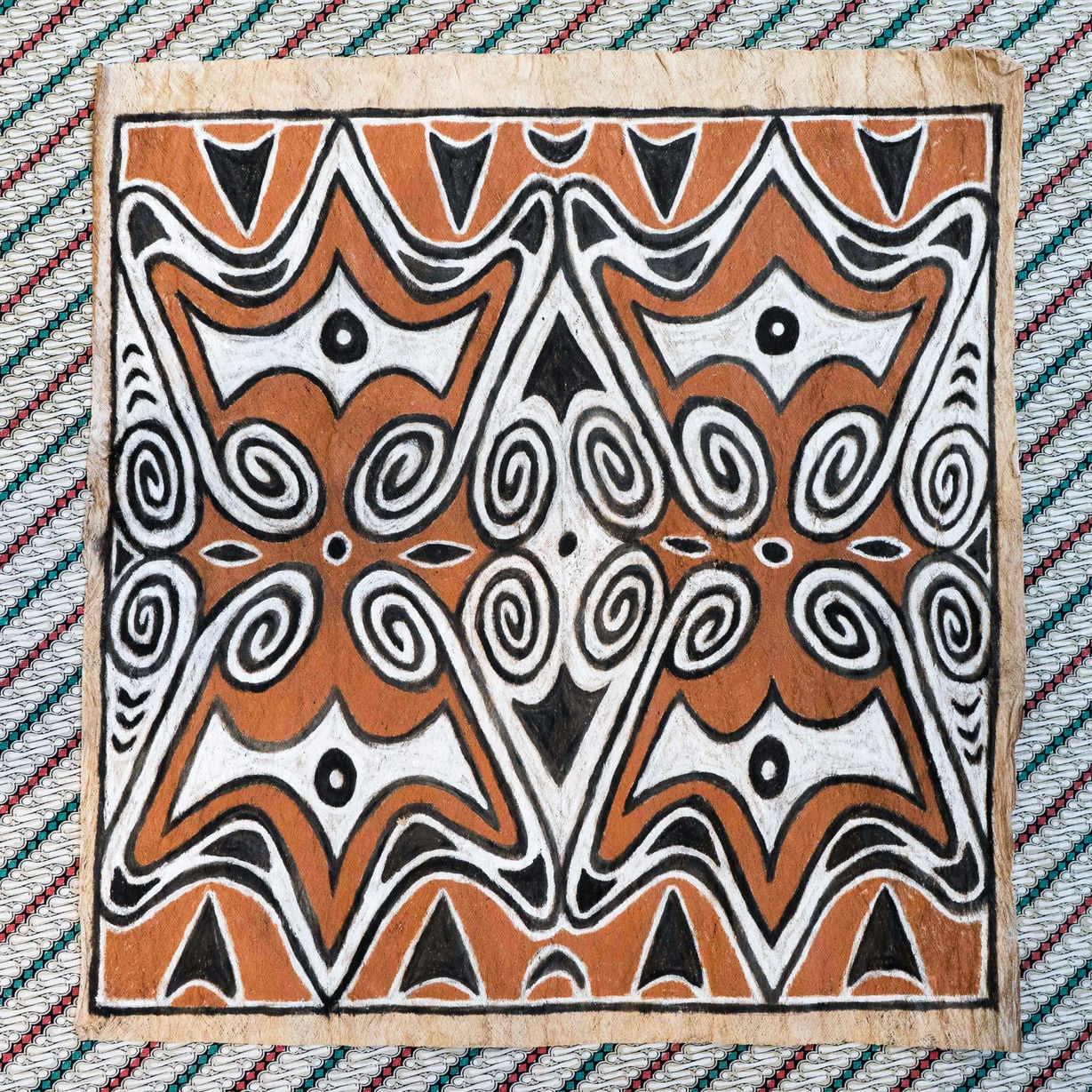 Een Indonesisch maroschilderij. Een maro is een stuk uit boombast geklopte lap waarop traditionele Papua-motieven getekend zijn. 