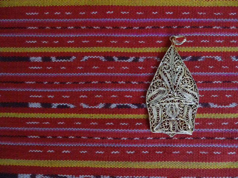 Deze prachtige gouden hanger is geïnspireerd op de Wayang Gunungan, de berg die gebruikt wordt in het wayangspel. 