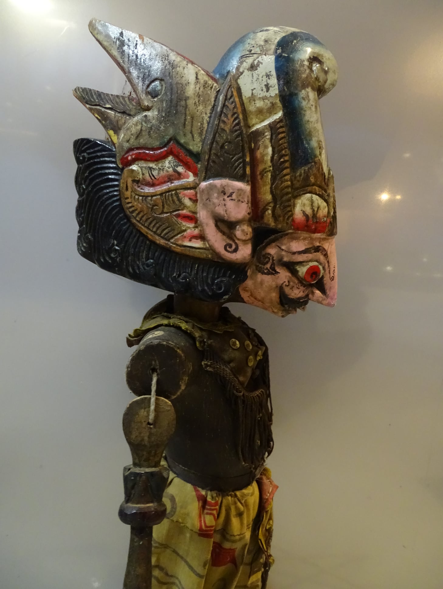 Een Wayang pop van het karakter Santanu, gemaakt uit hout met metalen en stof. De pop is met kleuren beschilderd.